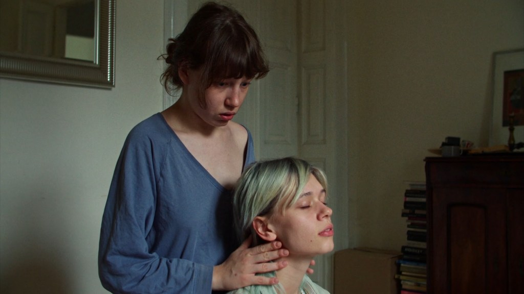 Young woman standing behind a girl, sitting in trance