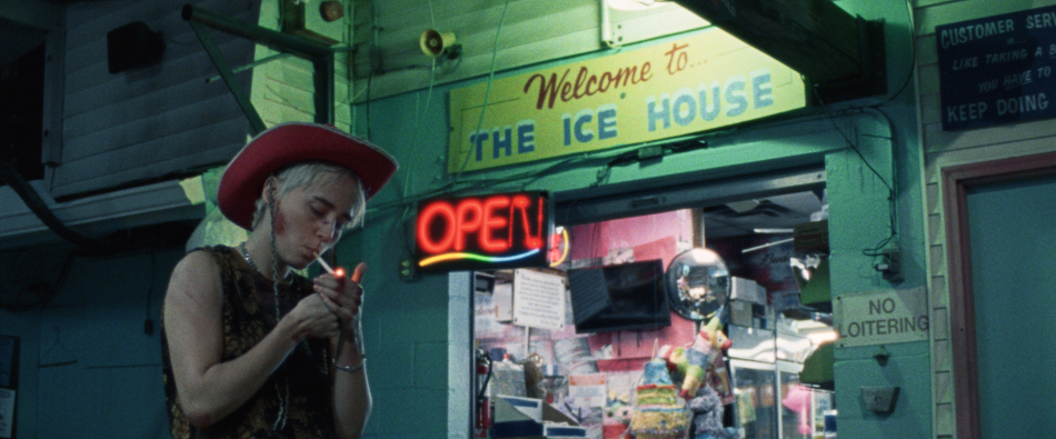 Young woman lighting a cigarette in front of store