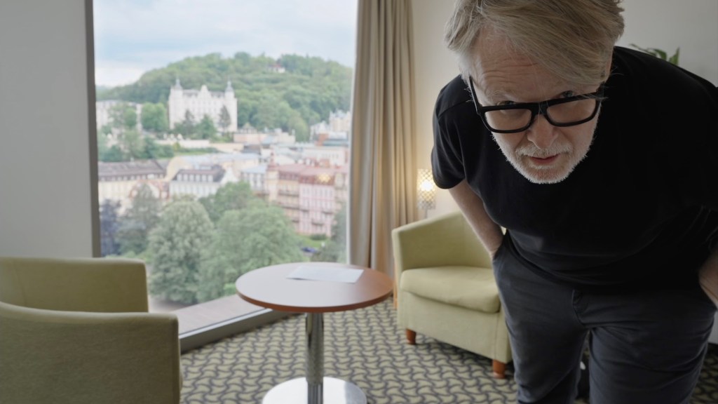 Filmmaker adjusting camera in hotel room setting