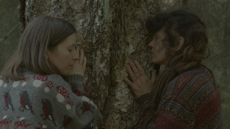 Irene Kaltenborn & protagonist leaning and listening to tree