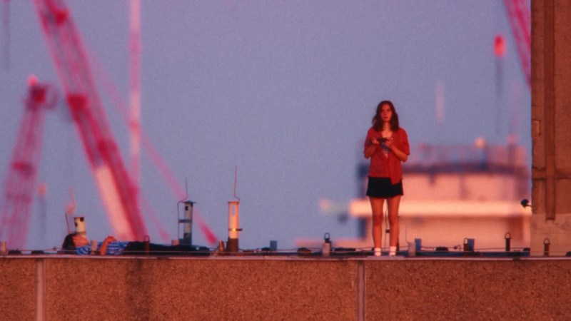 Jessie standing on rooftop, looking at horizon