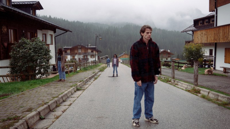Matteo standing motionless on village street